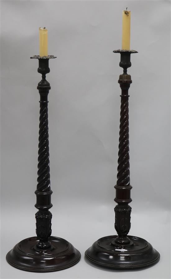 A pair of carved wooden barley twist candlesticks